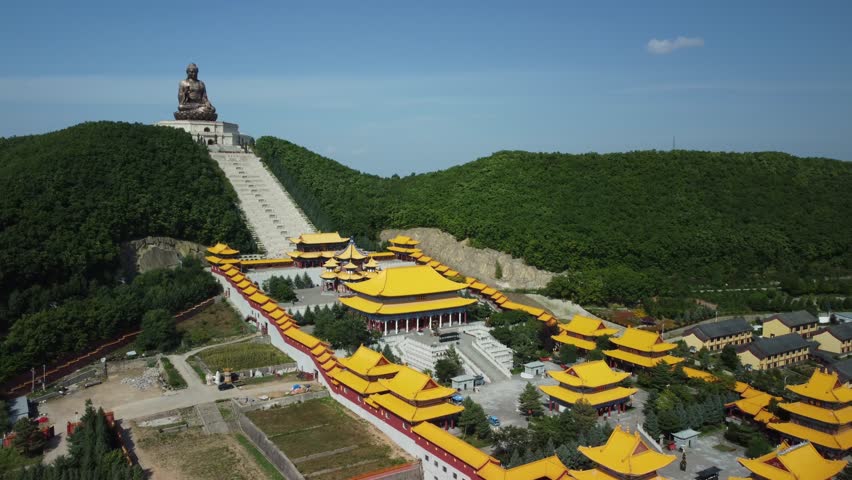 Aerial view of the Golden Buddha statue at Liudingshan Cultural Tourism Area in Dunhua City, Jilin Province, China. Massive golden statue overlooking Zhengjue Temple and facing the Changbai Mountain