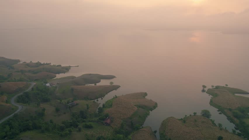 Aerial view of Chacha Kota Island hills in Banswara, Rajasthan, during the monsoon — showcasing lush green landscape, surrounding water, distant hills, and the soft morning sunrise light.