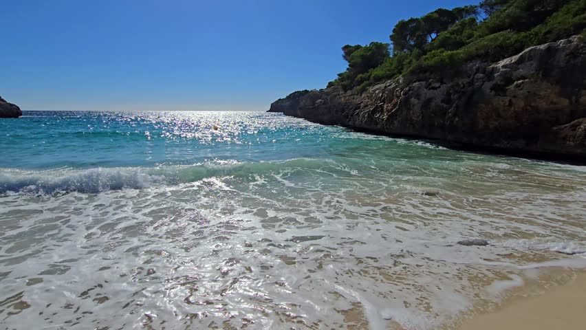 Turquoise waves at Cala Anguila beach in Mallorca