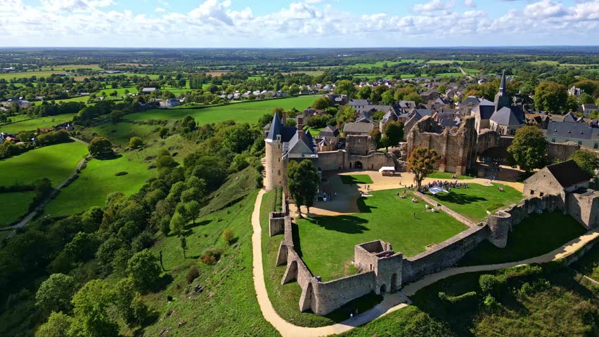 Medieval castle and fortified village of Sainte-Suzanne, Mayenne, France, showing ancient stone walls, Gothic church, and green countryside in the Pays de la Loire region, slow drone pan