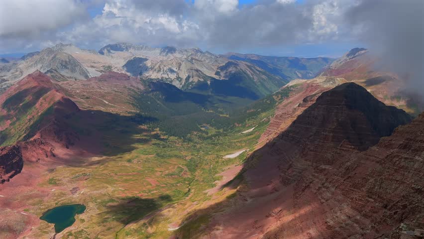 North Maroon Peak Aspen Snowmmass Maroon Bells Wilderness valley Capitol Peak Mount Snowmass Colorado summer panoramic view fog fourteener Elk Range Rocky Mountains rugged terrain pan left