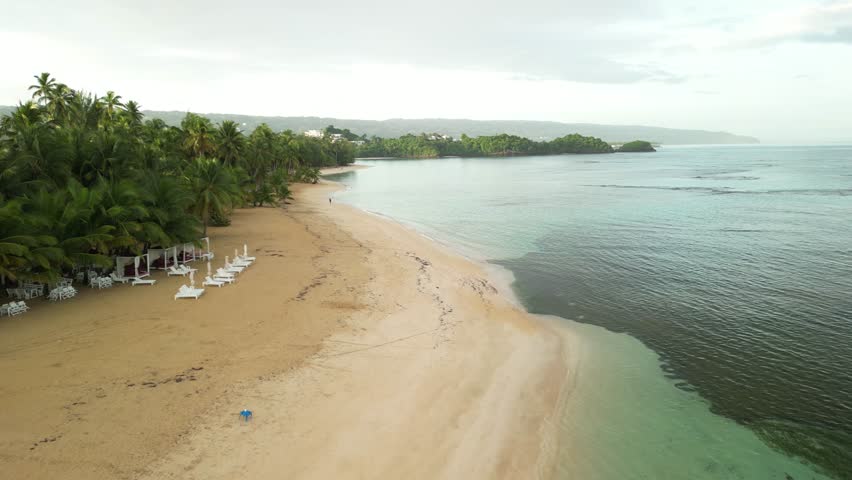 Cinematic sunrise scene with warm glow, calm sea, and one person from far away enjoying the morning