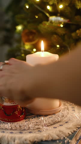 Vertical video. Christmas decorations, cozy home decor concept. Hand places Christmas snow globe with snowflakes on table.