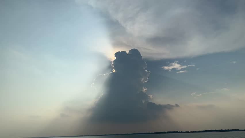 Sunlit Clouds Over Calm Waters at Sunset