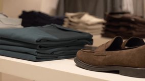 Stylish folded garments arranged on shelves in fashion boutique. Retail display of mens polo shirts and shoes. Elegant store shopping concept, modern lifestyle and clothing choice.  - Powered by Shutterstock - Get 15% off with code: PIKWIZARD15