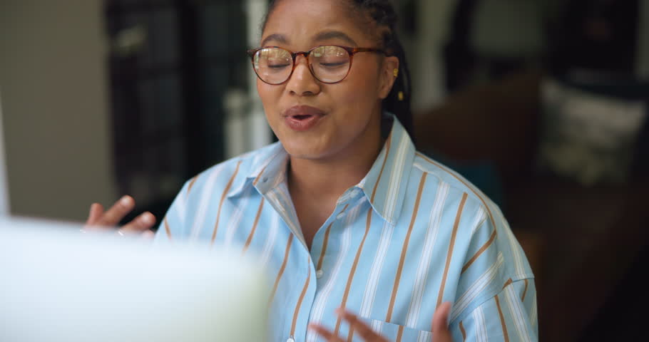 Woman, video call and online meeting with computer for virtual discussion or chat in home. Female person, remote work or freelancer talking with glasses for conversation or communication in house