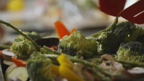 A plate of vegetables including broccoli, peppers, and mushrooms. The broccoli is cut into pieces and is being served with a red spatula - Powered by Shutterstock - Get 15% off with code: PIKWIZARD15