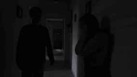 Girlfriend crying after argument while boyfriend tries to comfort her in dark hallway, emotional breakdown and relationship tension - Powered by Shutterstock - Get 15% off with code: PIKWIZARD15