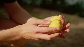 Man holding yellow lemon under running water. Teenager rinsing fresh produce while water splashes. Boy cleaning fruits outdoors with falling droplets - Powered by Shutterstock - Get 15% off with code: PIKWIZARD15