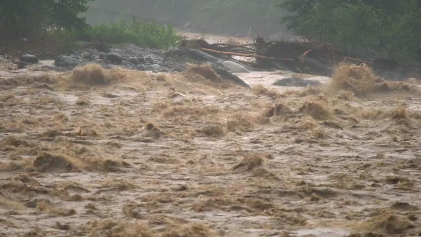 Rapid, dangerous floodwaters rushing through land, illustrating natural disaster, extreme weather, and water hazards in dramatic detail.