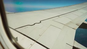 Airplane flying above landscape with fields and blue sky, view from window porthole. Jet cruising over rural terrain with farmland stretching below. Aircraft soaring above countryside under clear sky - Powered by Shutterstock - Get 15% off with code: PIKWIZARD15