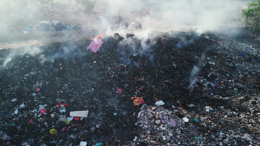 Burning trash in dump, industry drone shot in Bali, ecology concept