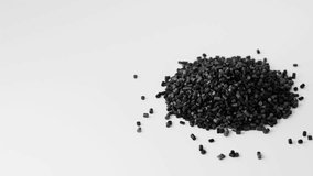Black plastic polypropylene granules pouring from cup on a pile of granules, masterbatch polymer grain on white backdrop. HDPE or PVC resin pellets. 3d render animation. 3D Illustration - Powered by Shutterstock - Get 15% off with code: PIKWIZARD15