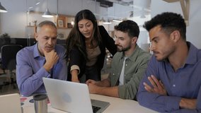 Diverse business team collaborating at a meeting table using one shared laptop. Coworkers working together to analyze data and plan company strategy. Business teamwork concept. - Powered by Shutterstock - Get 15% off with code: PIKWIZARD15
