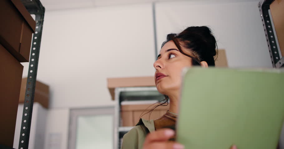 Shipping, tablet and scroll with woman in warehouse for delivery information, inventory and logistics. Online shopping startup, distribution shipment and low angle with person for courier postage