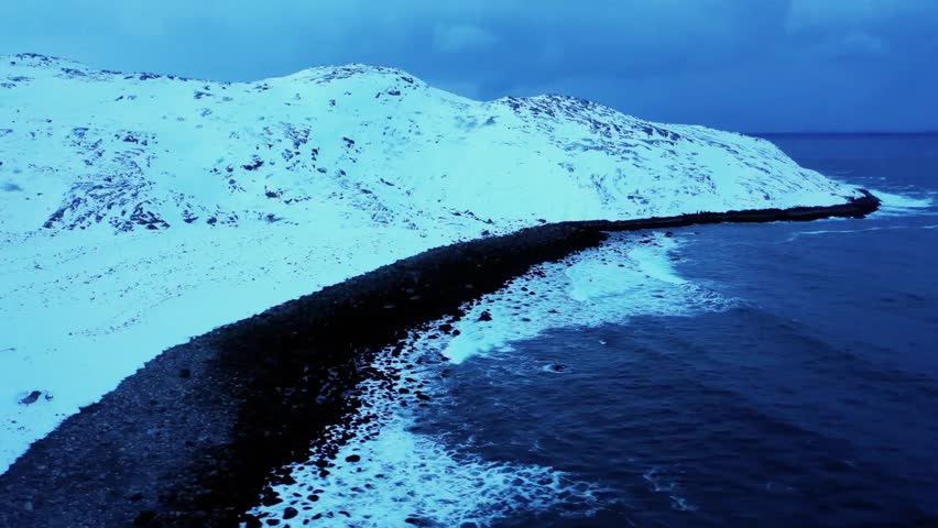 Dolly shot to the right over Dragon Egg Beach in Teriberka, Murmansk, Russia, showcasing rugged coastline, rocky formations, and Arctic seascape.