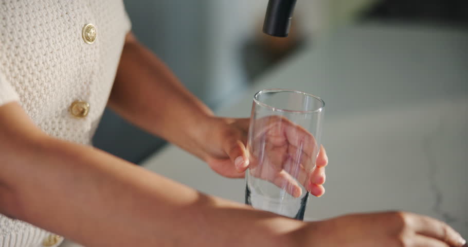 Glass, water and tap with hands of woman in kitchen of home for detox drinks, mineral hydration and health. Electrolytes, wellness and aqua with person and faucet in apartment for liquid and beverage