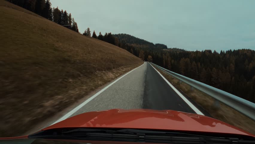 Car Driving on a Winding Autumn Road