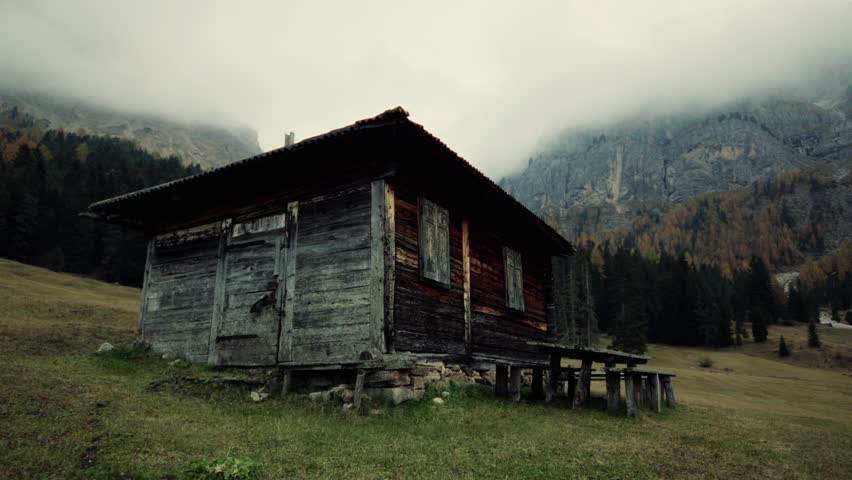 House Surrounded by Mountains, Green Meadows, and Clouds