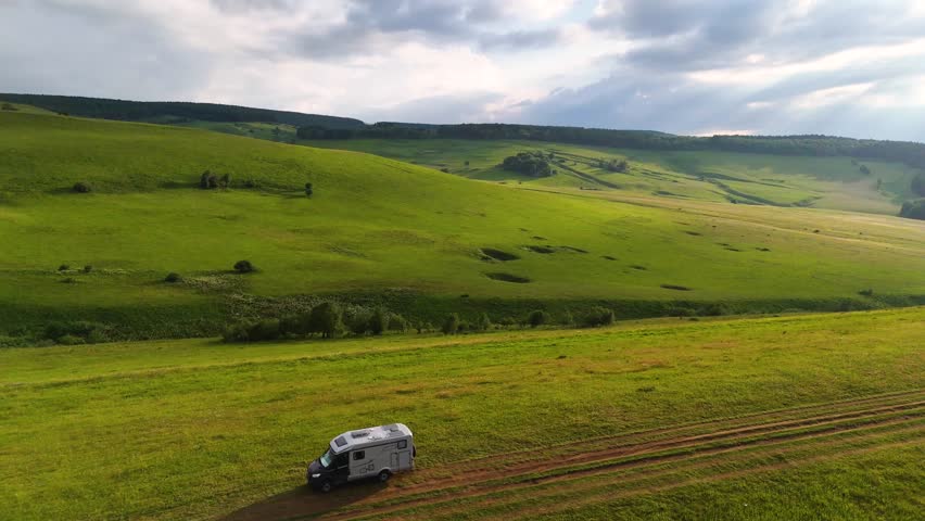 Drone flight over a motorhome in the Caucasus Mountains at sunset