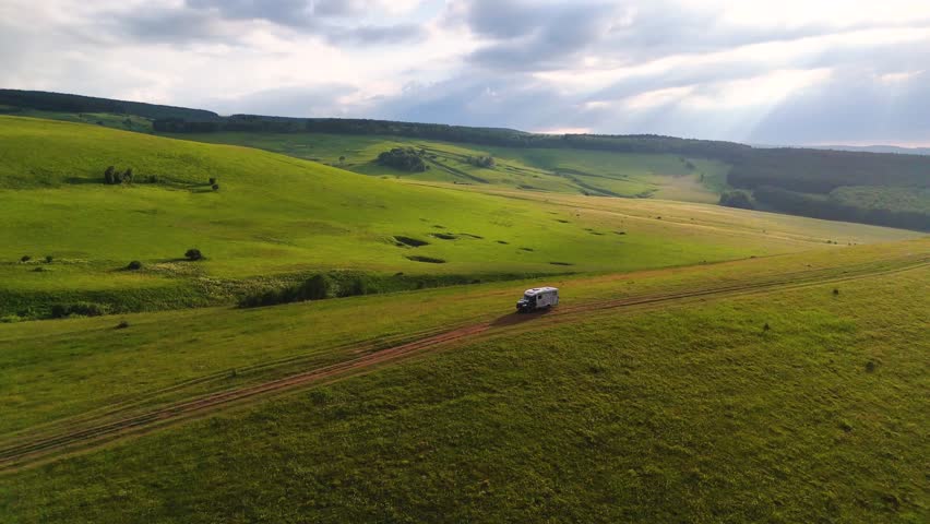 Drone flight over a motorhome in the Caucasus Mountains at sunset