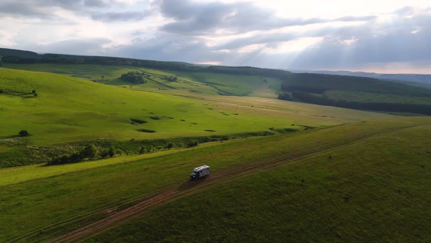Drone flight over a motorhome in the Caucasus Mountains at sunset