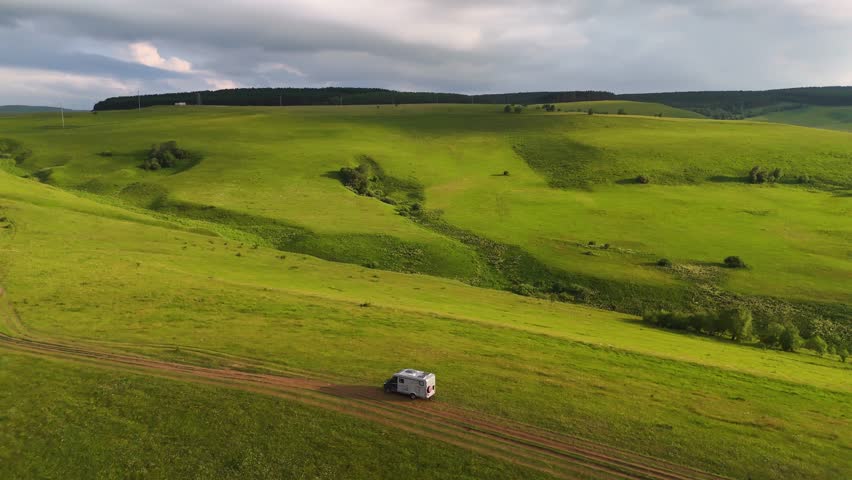 Drone flight over a motorhome in the Caucasus Mountains at sunset