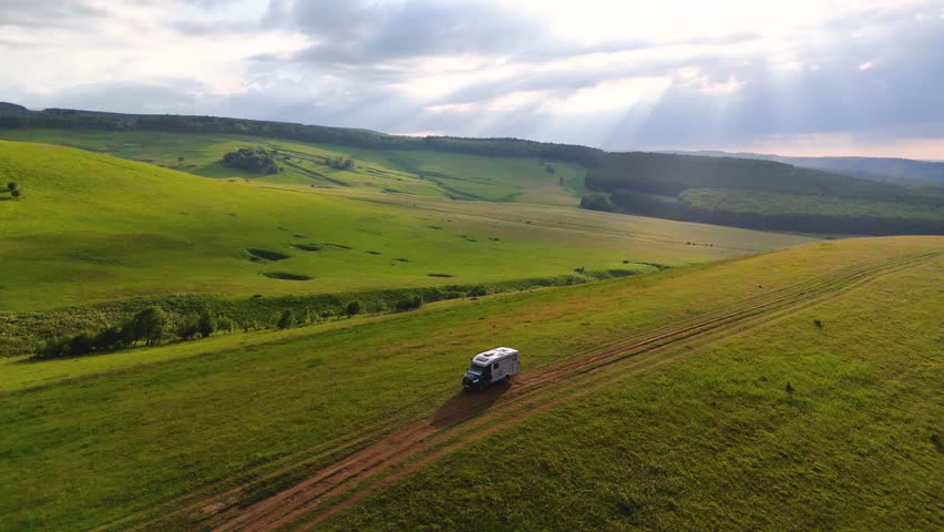 Drone flight over a motorhome in the Caucasus Mountains at sunset