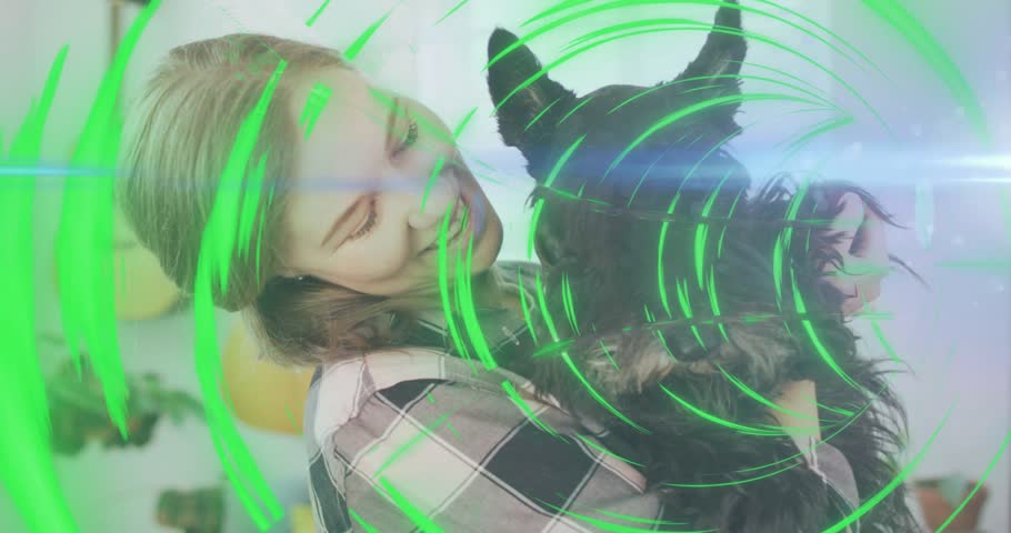 Woman lifting, cradling dog in home with animated rings sweeping across frame signaling pet care. Canine, affection, warmth, holding, companion, livingroom, guitars