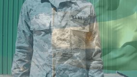 Male airman standing, tilting head then saluting, honoring flag with sun-emblem overlay drifting. Camouflage, military, uniform, outdoor, banner, symbol, bright - Powered by Shutterstock - Get 15% off with code: PIKWIZARD15