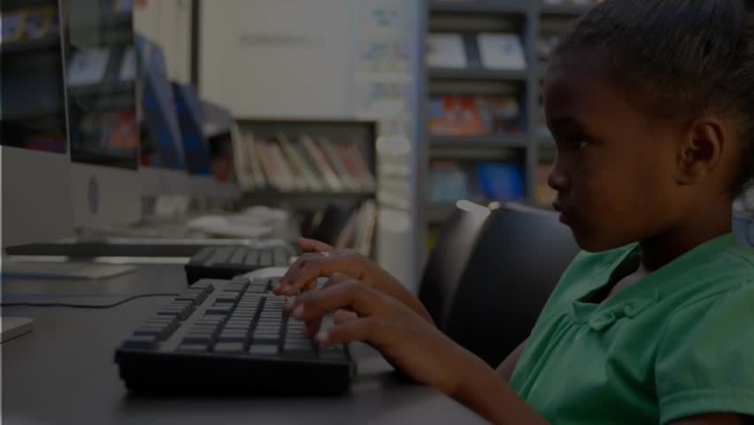 Student girl typing in school lab, monitor showing assignment, pressing keys, completing task. Focus, learning, education, technology, classroom, desk, shelves - Powered by Shutterstock - Get 15% off with code: PIKWIZARD15