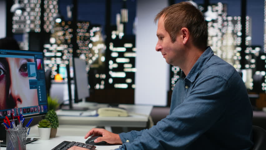 Graphic developer working with photo editing software at the office, digital media production with professional tools. Dual monitors for productivity in the graphic design industry. Camera B.