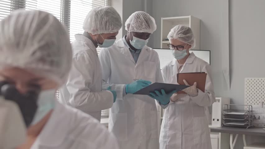 A diverse group of scientists stands by a bright lab window, discussing research data and collaborating on an important scientific project.
 - Powered by Shutterstock - Get 15% off with code: PIKWIZARD15