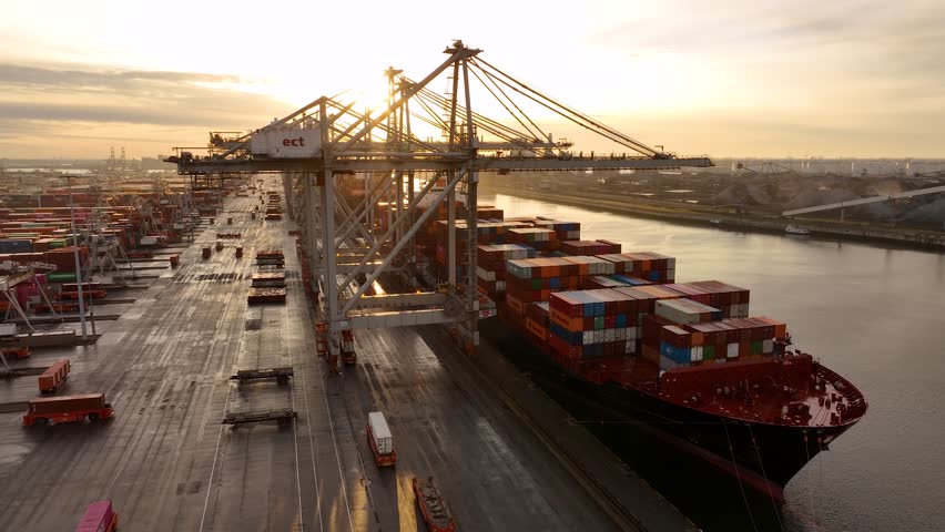 Rotterdam, Netherlands, Drone shot of modern industrial port with containers between night and sunrise. Panorama over sunset. It is an import and export cargo port where is a part of shipping dock
