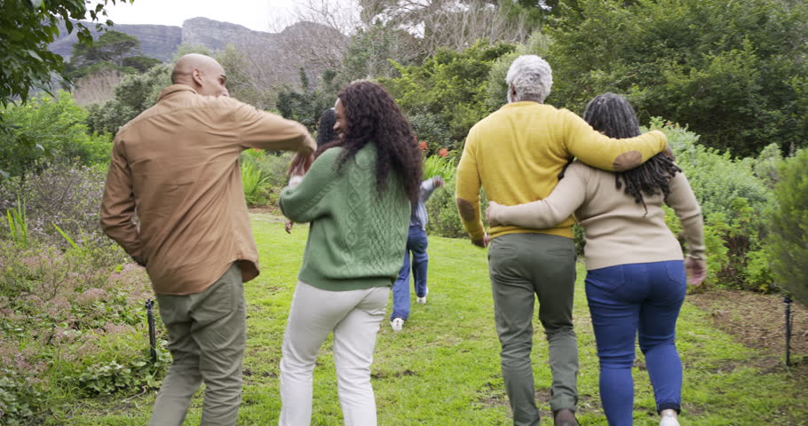 Walking family group chatting on path with daughters spotting grey house and running toward lawn. Outdoor, companionship, countryside, lifestyle, harmony, leisure, natural