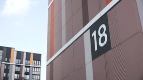 Large number on end of modern building with stylish paint in new residential district against sky. Numbers 18 of house number and navigation in city and district. - Powered by Shutterstock - Get 15% off with code: PIKWIZARD15