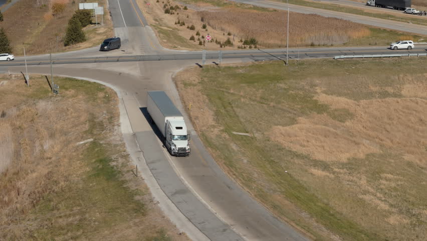 Drone view of delivery truck driving toward to a scenic state highway. Logistics and transportation concept. 