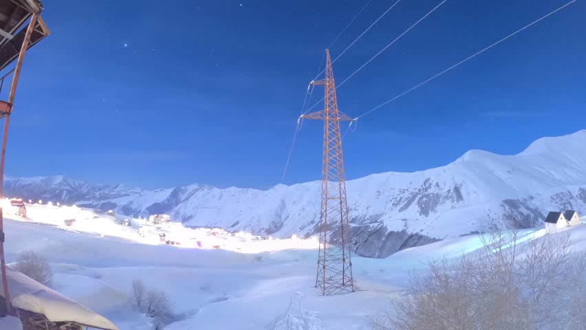 Timelapse of star trails over the city lights at night in the mountains. Georgia. Gudauri.