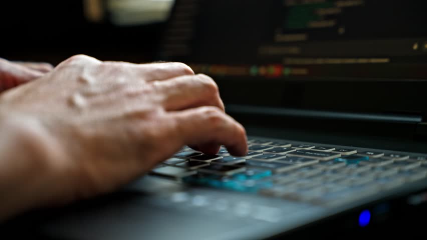 Closeup view of hands typing on a laptop keyboard with selective focus and shallow depth of field. Soft lighting and natural working atmosphere