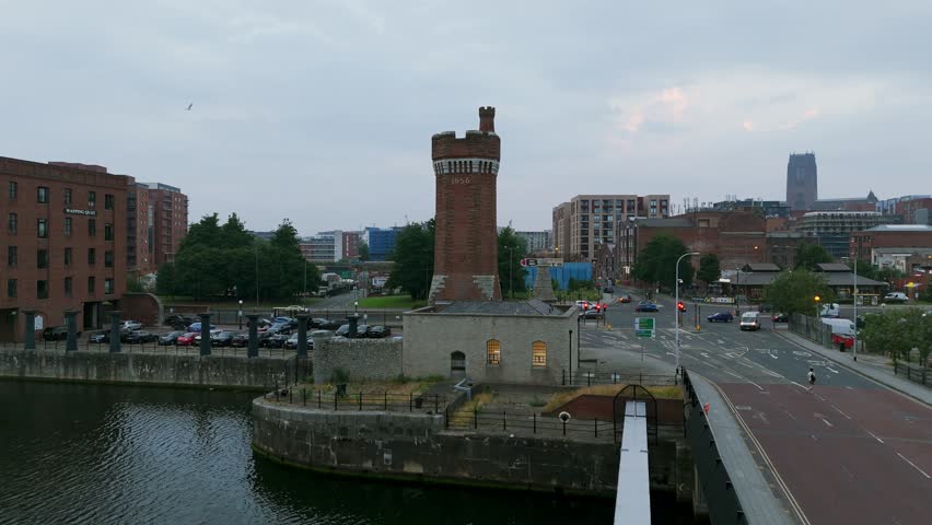 Liverpool, UK. drone orbit around Victoria Tower at the docks, with waterfront basin, road bridge and city skyline in view under soft overcast light