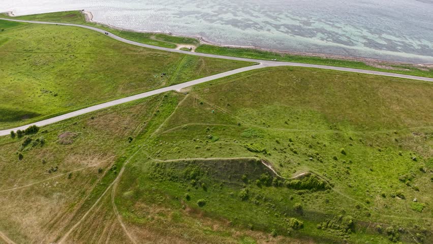 Aerial drone footage of Dragsmur in Denmark, the historic Viking land crossing connecting Helgenæs to the mainland, showing grassy terrain and coastal views