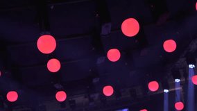 Ceiling installation features hanging LED spheres glowing in pink, red, and white, paired with moving head stage lights that cast beams across venue, creating a vibrant and immersive event atmosphere. - Powered by Shutterstock - Get 15% off with code: PIKWIZARD15