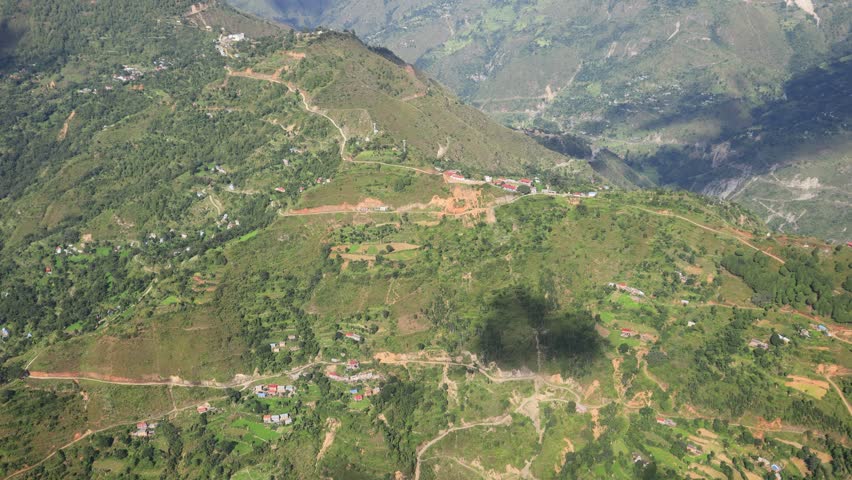 Kathmandu city and valley hills viewed from flying helicopter featuring urban landscape, green slopes, hazy sky and wide aerial scenery representing Nepal environment and mountain region landform spot