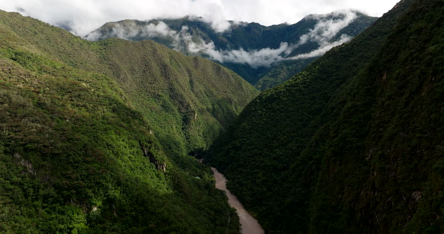 Urubamba river flows though lush mountainous valley near Aguas Calientes, drone