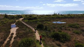Active senior couple on e-bikes beside sea beach on scenic Parco Maremma trail. Tuscany aerial. - Powered by Shutterstock - Get 15% off with code: PIKWIZARD15
