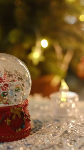 Vertical video. Christmas snow globe. Christmas background with festive cozy atmosphere.