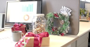 Camera starting pan right, revealing cubicle with Merry Christmas wreath, gifts, candy-cane laptop. Festive, holiday, workspace, celebration, interior, seasonal, cheerful - Powered by Shutterstock - Get 15% off with code: PIKWIZARD15