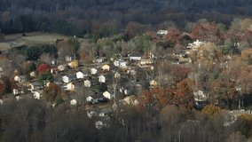 Sweeping aerial panorama of a peaceful American suburban landscape among rolling hills, rows of houses and vibrant autumn trees in midday light, evoking tranquil living and green connectivity. - Powered by Shutterstock - Get 15% off with code: PIKWIZARD15
