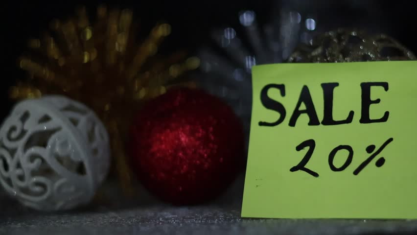 Several Christmas decorations with a yellow note indicating a 20% savings, surrounded by colorful lights. Christmas and New Year's decorations