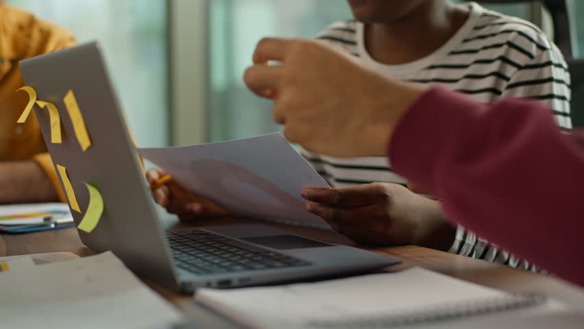 Informal business team collaboration Arabian man examining papers African woman holding chart comunicate Indian male colleague pointing at laptop casual diversity teamwork modern office briefing job - Powered by Shutterstock - Get 15% off with code: PIKWIZARD15